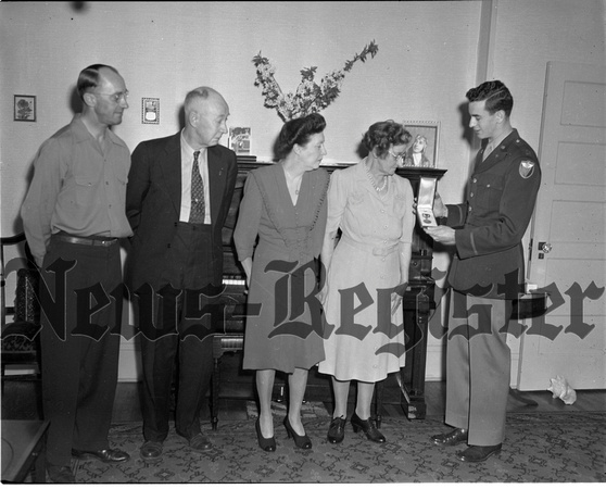 1945-4-26 Mr. and Mrs. H.W Moore and Ira Moore receive air medal for Lt. Alvin W. Moore(missing).jpeg